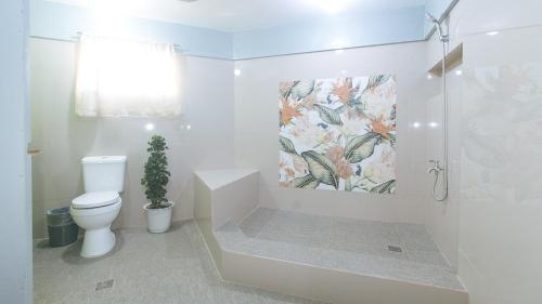 a white bathroom with a toilet and a shower at RedDoorz @ Yahweh Spring Retreat & Resort Laguna in Calamba