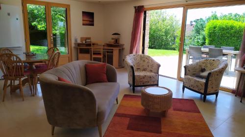 un salon avec un canapé, des chaises et une table dans l'établissement Studio Nature enchantée Annecy, à La Balme-de-Sillingy