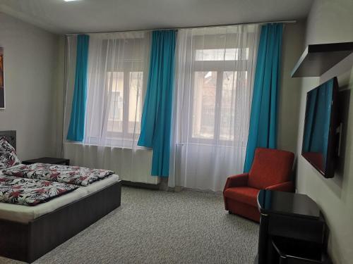 a bedroom with a bed and a chair and a window at Csobánc apartman in Tapolca