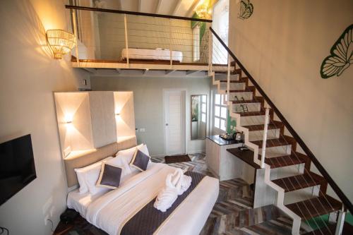 a bedroom with a bed and a staircase at La Papillon Maison in Puducherry