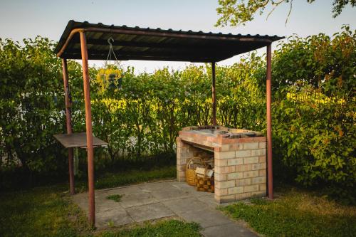 an outdoor grill with a roof on top of it at Atpūtas namiņš Skudriņas in Sesava