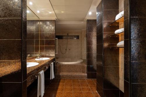a bathroom with two sinks and a bath tub at Exe Boston in Zaragoza