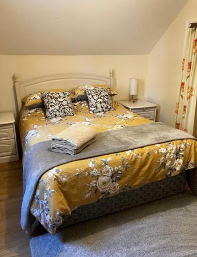 - une chambre avec un lit doté d'une couverture jaune et d'oreillers dans l'établissement Le Petit Parc, à Saint-Brice-de-Landelles