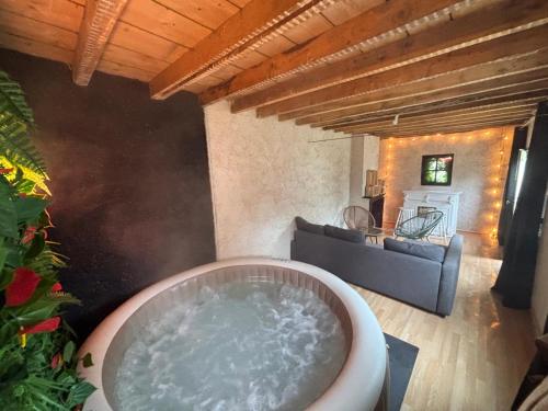 a bath tub in a living room with a couch at Maison de campagne à 2h de Paris in Droué