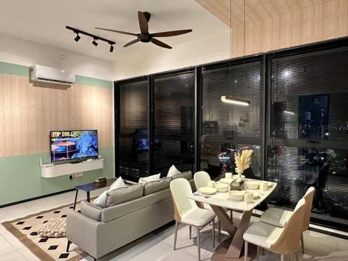 a living room with a couch and a table and a tv at Urban Emerald Seaview 6Pax 3Queen 3Room 2Bath 2Carpark with Infinity Pool in Jelutong