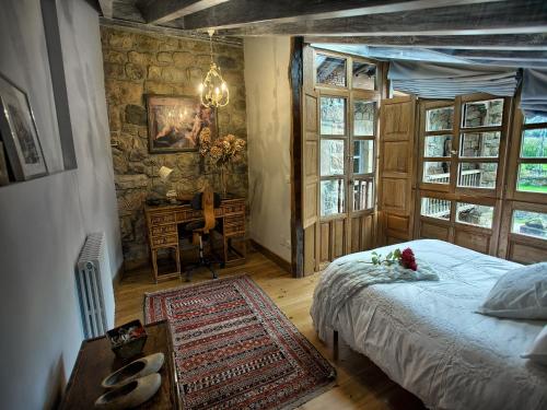 a bedroom with a bed and a desk in it at La Curva De María in Terán