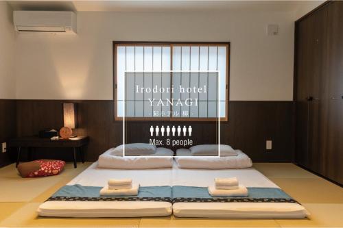 a room with a large bed with towels on it at Irodori Hotel YANAGI in Fukuoka