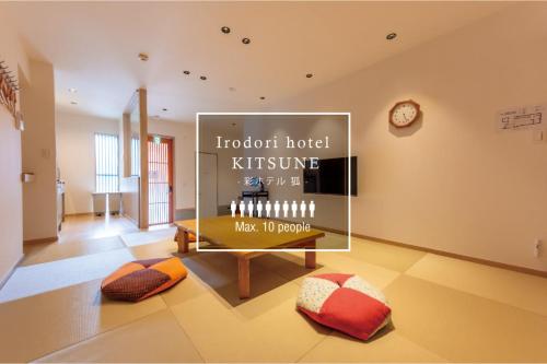 a room with a table with a clock on the wall at Irodori Hotel KITSUNE in Fukuoka