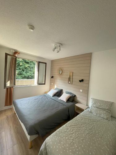 a bedroom with two beds and a window at Souleih d'Ossau 202 in Bielle