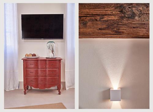 a room with a television and a dresser with a lamp at DORA maison de charme in Ivrea