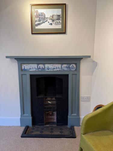 a fireplace in a living room with a picture on the wall at The Staff Quarters in Shifnal