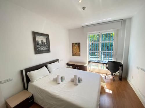 a bedroom with a large white bed and a window at Apartamento Jara, playa, piscina, AC, Wi-Fi in Sanlúcar de Barrameda