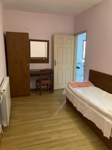 a bedroom with a bed and a door and a chair at Вилно селище Баташки хан in Tsigov Chark