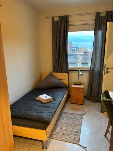 a small bedroom with a bed with a window at Budgethotel Stadtbett Wolfsburg in Wolfsburg