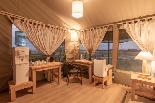 a tent with two tables and chairs and windows at MAISHA SWEETWATERS CAMP in Ol Pejeta Conservancy