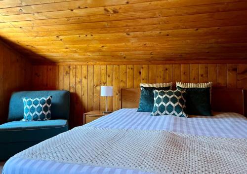 a bedroom with a bed and two blue chairs at Appartement Le Moulin - 1771 in Grimentz