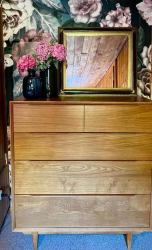 a dresser with a mirror and a vase with flowers on it at Appartement Le Moulin - 1771 in Grimentz