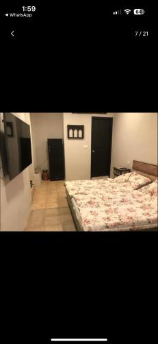 a bedroom with two beds and a television in it at Parigold in New Delhi