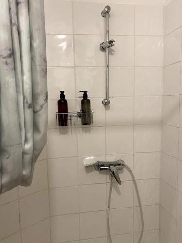 La salle de bains est pourvue d'une douche avec 2 bouteilles murales. dans l'établissement Studio Cozy centre-ville, à Nîmes