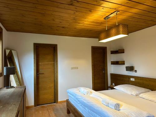 a bedroom with two beds and a wooden ceiling at Resort Drevenice Terchova in Terchová