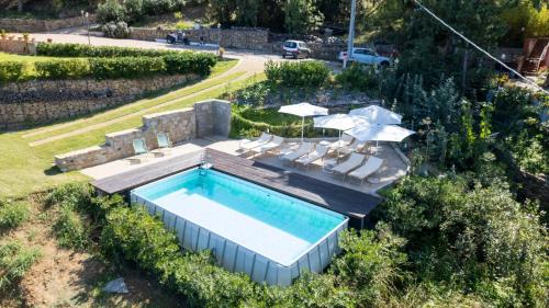 an overhead view of a swimming pool with chairs and umbrellas at B&B Le Ginestre in Cefalù
