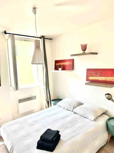 - une chambre avec un lit et une serviette noire dans l'établissement appartement Vieux Port Clim, à Marseille