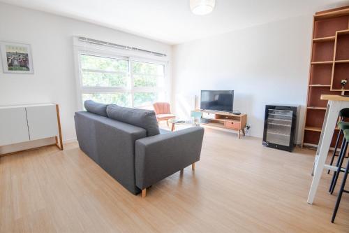 un salon avec un canapé et une télévision dans l'établissement Les Provinciales, à Tours