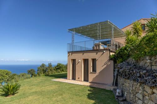 a house with a balcony on top of a stone wall at B&B Le Ginestre in Cefalù