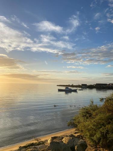 un bateau assis dans l'eau près d'une plage dans l'établissement Camping SIBLU Les Viviers 4 étoiles, à Lège-Cap-Ferret