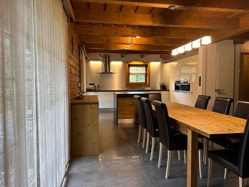 a kitchen and dining room with a wooden table and chairs at Resort Drevenice Terchova in Terchová