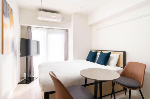 a bedroom with a bed and a table and chairs at Leclerc Nishi-Shinjuku in Tokyo