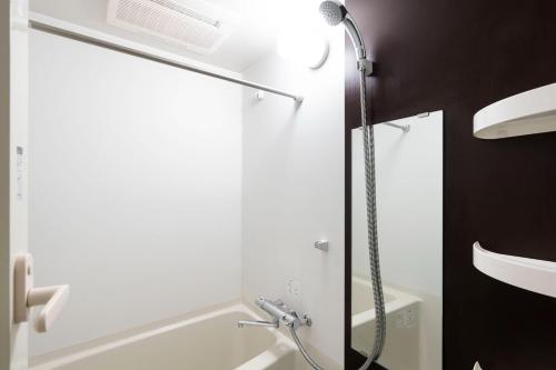 a shower in a bathroom with a glass door at Leclerc Nishi-Shinjuku in Tokyo
