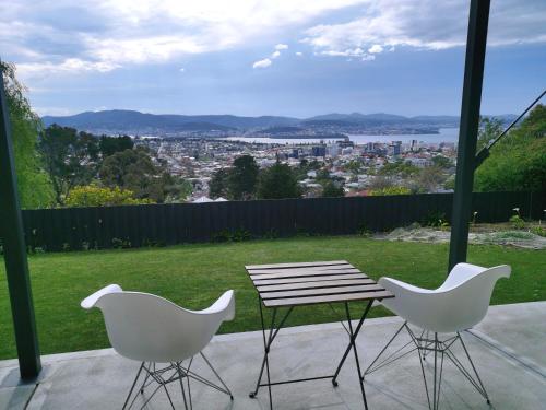 a table and two chairs on a patio with a view at Hobart Retreat with City and Water View in West Hobart