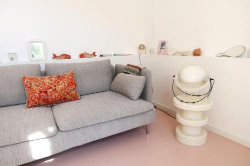 un salon avec un canapé gris et une table dans l'établissement Maisonnette du Roucas, à Marseille
