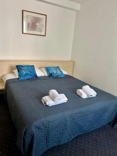 a bedroom with a bed with towels on it at Hotel Pacific in Timişoara
