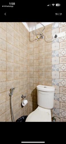 a bathroom with a toilet and a toilet paper dispenser at Parigold in New Delhi