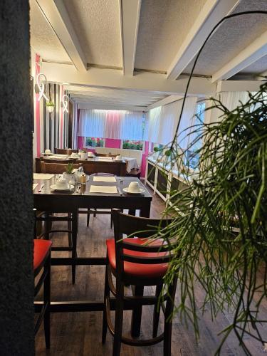 a dining room with a table and chairs and a room with at Hotel Schloßschenke in Idar-Oberstein
