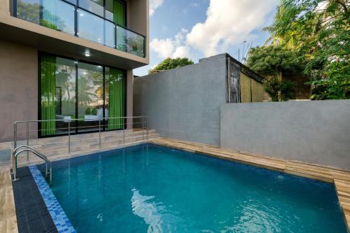a swimming pool in front of a house at Green Vibe Apartments in Nugegoda