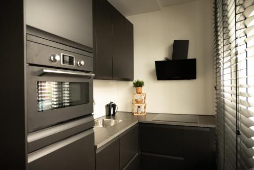 a kitchen with black cabinets and a sink at PURMERENT Apartments in Purmerend