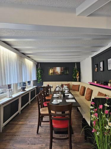 a dining room with a long table and a couch at Hotel Schloßschenke in Idar-Oberstein