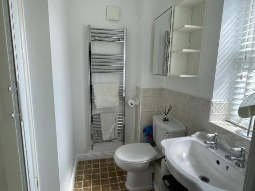 a white bathroom with a toilet and a sink at Spacious four bed detached home in Nottingham in Nottingham
