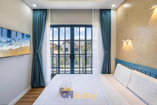 Un dormitorio con una cama y una ventana grande. en Biệt thự nghỉ dưỡng Phan Thiết, en Phan Thiet
