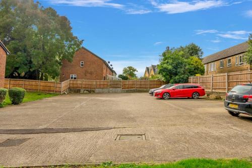 a red car parked in a parking lot at Private Studio Apartment In Dartford DA1 Free Parking TFL Zone 6 in Slades Green