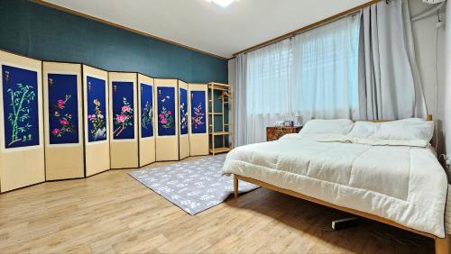 Un dormitorio con una cama y cuadros en la pared. en Byulchae Guest House - Foreigner Only, en Seúl