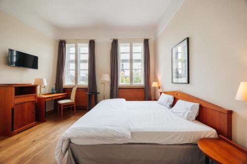 a hotel room with a bed and a desk at Hotel Zum Erbprinzen in Schwetzingen