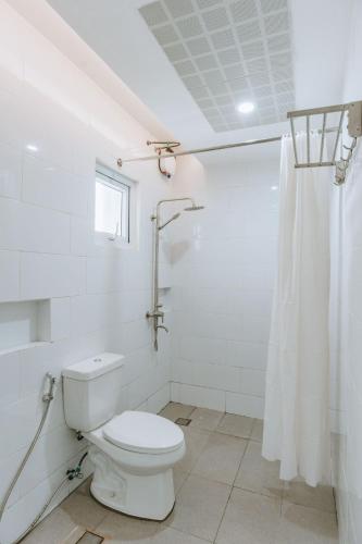 a white bathroom with a toilet and a shower at Diane Residences in Mabolo