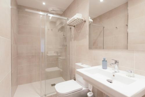 a bathroom with a shower and a toilet and a sink at Pension Del Mar in San Sebastián