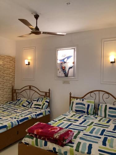 two beds sitting next to each other in a bedroom at Daman Pool Villa Bungalow in Marwad