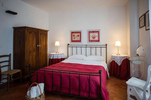 a bedroom with a large bed with a red blanket at Casale Giancesare Villa Agricola in Capaccio-Paestum