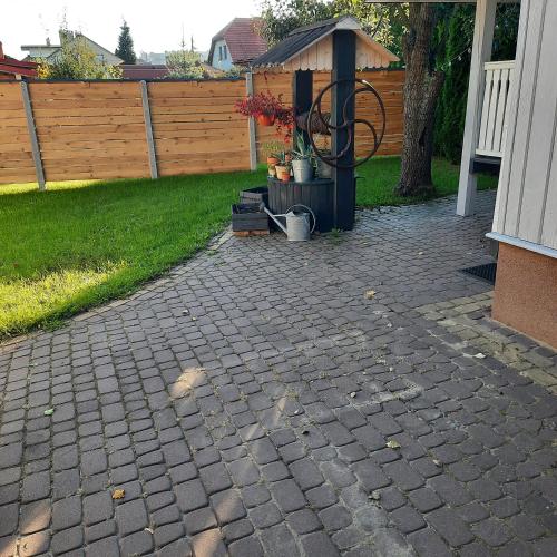 a backyard with a brick patio with a fence at CHILL-i-Domki in Sandomierz